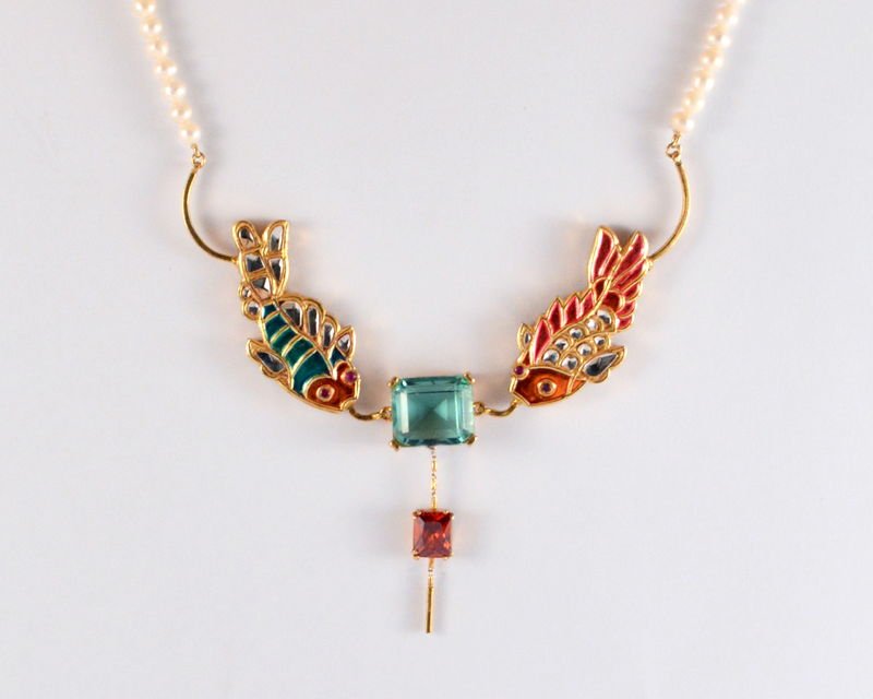 A Safari fish-pair necklace: two enamelled and kundan fish flanking a square topaz, with a zircon drop and a pearl string.